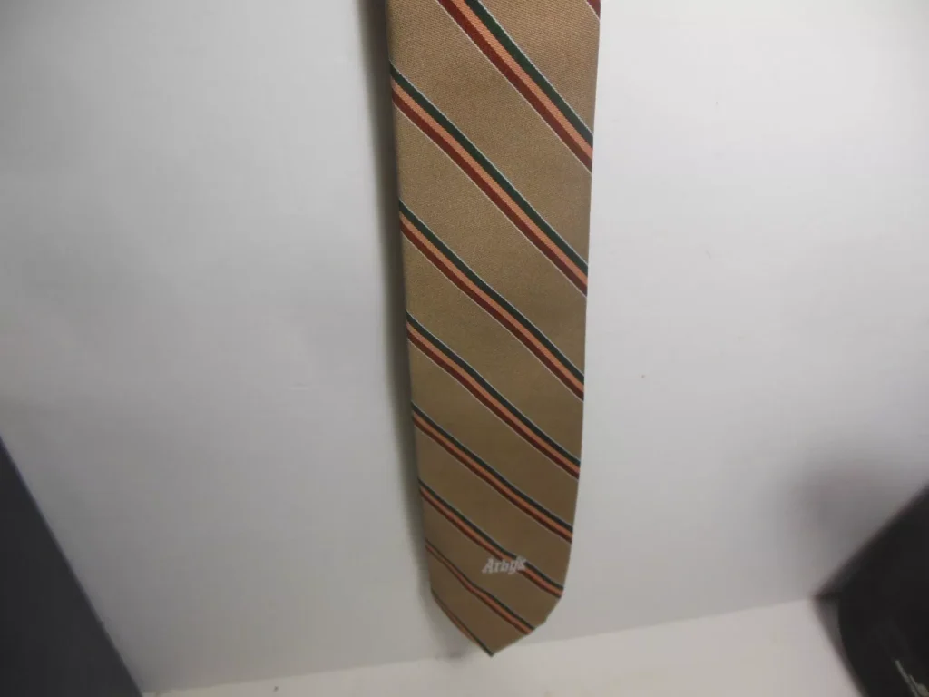 Image of the Vintage Arby’s Fast Food Employee Uniform Manager Tie, showcasing its tan color with stripes, made from polyester, as part of the historic management uniform.